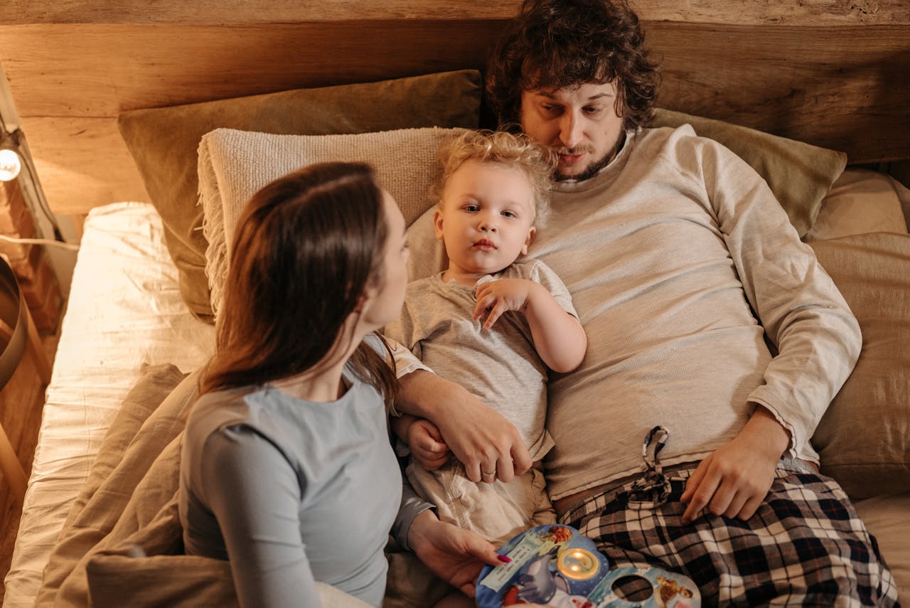 A peaceful family moment with parents and child relaxing in bed, embracing love and togetherness.